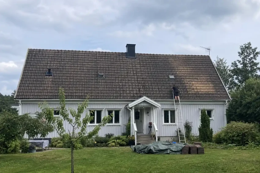 Villatak med slitna takpannor och stege lutad mot taket inför beslut om att byta eller renovera tak